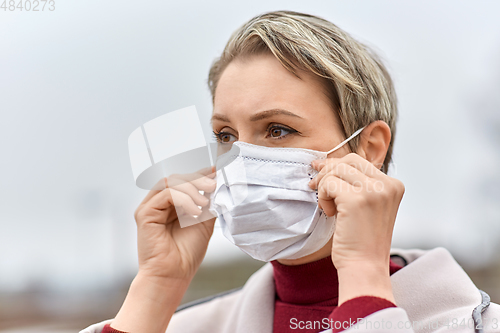 Image of young woman wearing protective medical mask