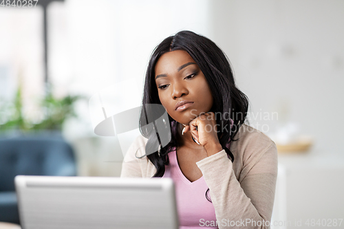 Image of bored woman with laptop working at home office