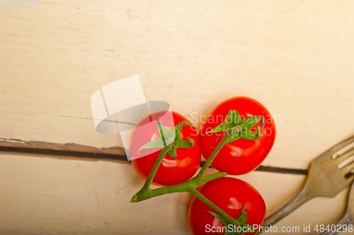 Image of ripe cherry tomatoes over white wood