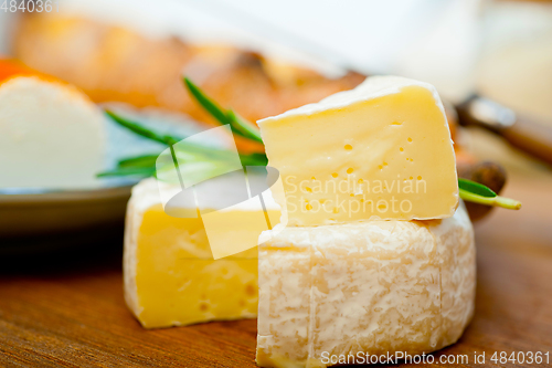 Image of French cheese and fresh  baguette on a wood cutter