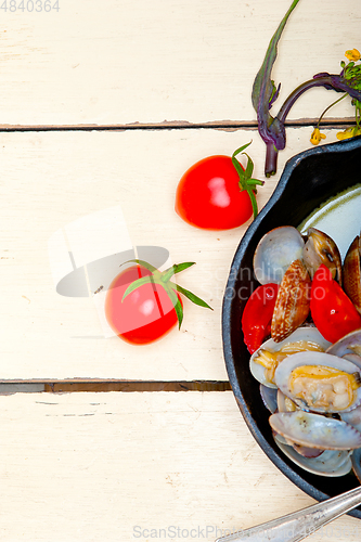 Image of fresh clams on an iron skillet