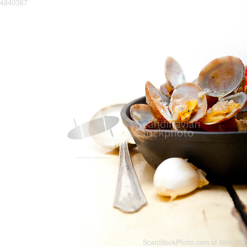 Image of fresh clams on an iron skillet