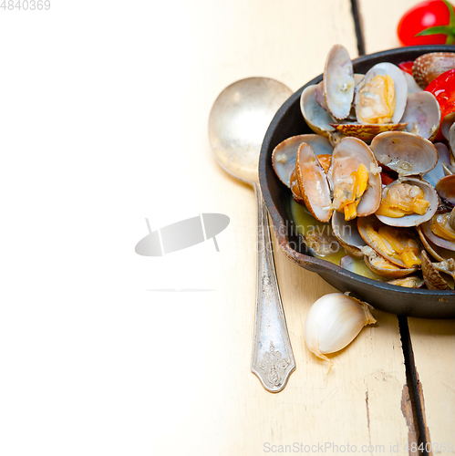 Image of fresh clams on an iron skillet