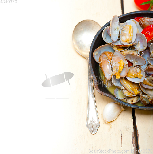 Image of fresh clams on an iron skillet