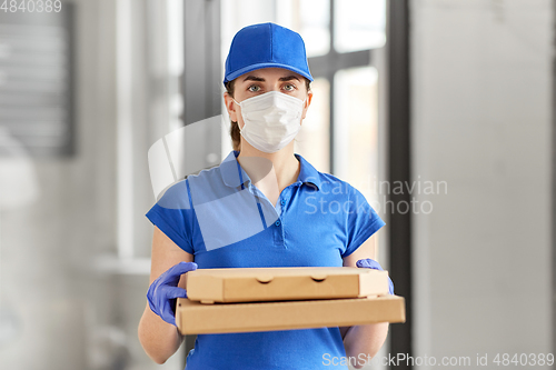 Image of delivery woman in face mask with pizza boxes