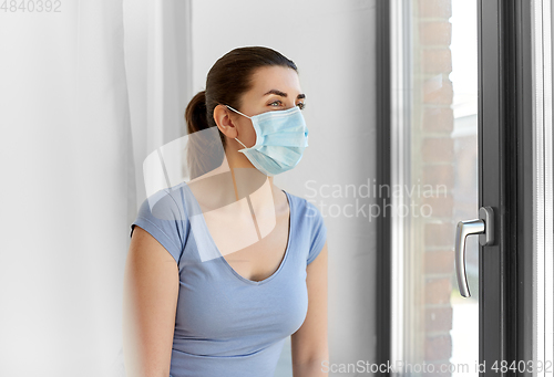 Image of sick young woman wearing protective medical mask