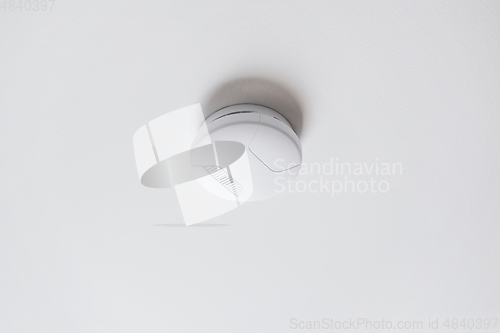 Image of smoke alarm, sensor or detector on white ceiling