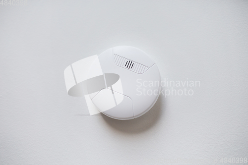 Image of smoke alarm, sensor or detector on white ceiling