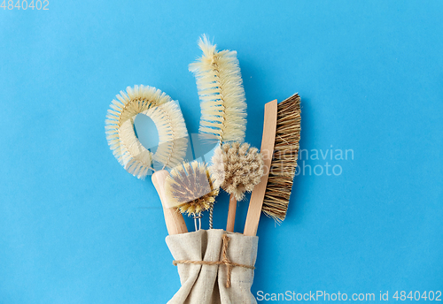 Image of different cleaning brushes on blue background