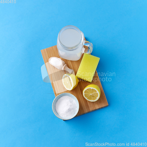 Image of lemons, washing soda and sponge on wooden board