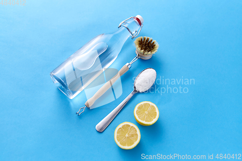 Image of lemons, washing soda, bottle of vinegar and brush