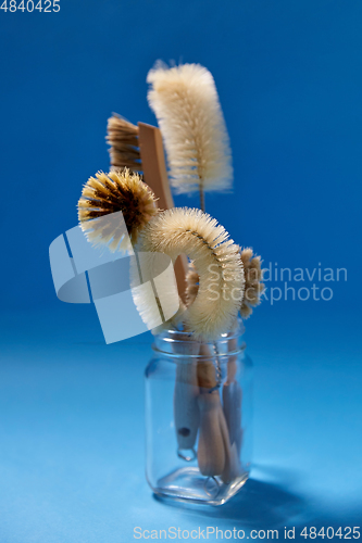 Image of different natural cleaning brushes in glass jar