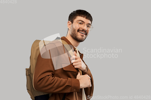 Image of smiling young man in glasses with backpack