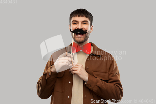 Image of smiling man with mustache and bowtie party props