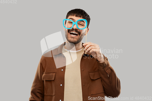 Image of happy smiling man with glasses party accessory