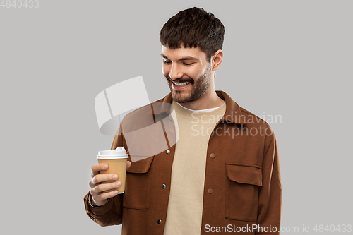 Image of smiling young man with takeaway coffee cup