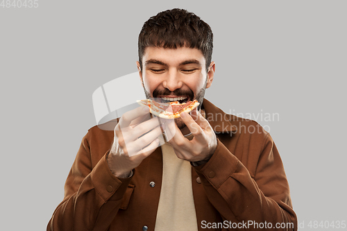 Image of happy smiling young man eating pizza
