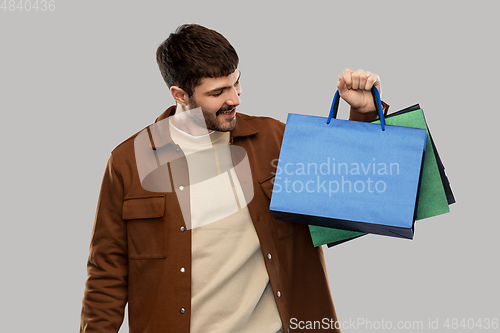 Image of happy smiling young man with shopping bags