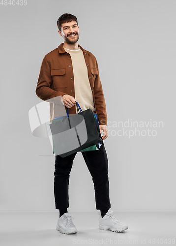 Image of happy smiling young man with shopping bags