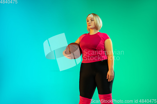 Image of Young caucasian plus size female model\'s training on gradient green background