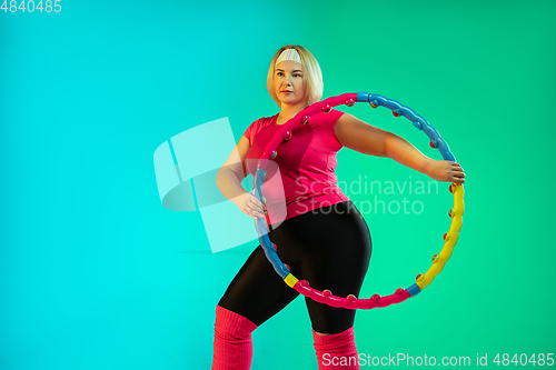 Image of Young caucasian plus size female model\'s training on gradient green background