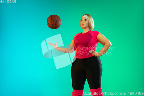 Image of Young caucasian plus size female model\'s training on gradient green background
