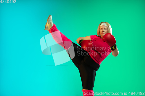 Image of Young caucasian plus size female model\'s training on gradient green background