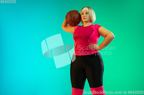 Image of Young caucasian plus size female model\'s training on gradient green background