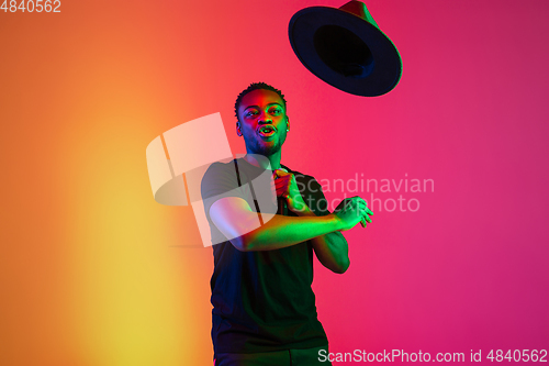 Image of Young african-american musician singing, dancing in neon light