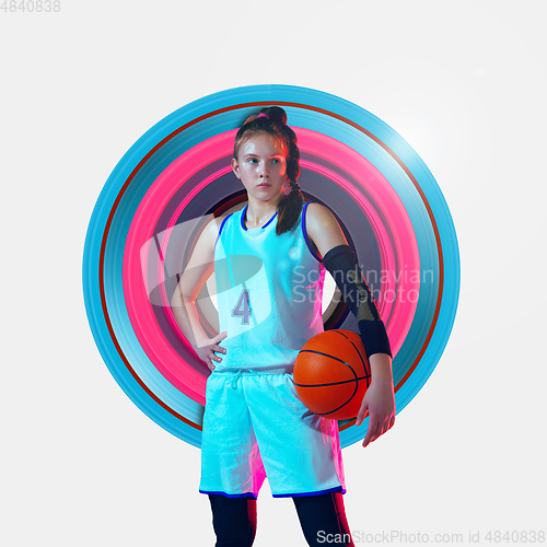 Image of Full length portrait of a female basketball player with ball