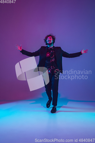 Image of Young caucasian musician dancing in neon light