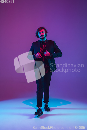 Image of Young caucasian musician dancing in neon light