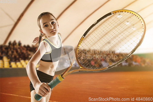 Image of Little caucasian girl playing tennis on sport court background