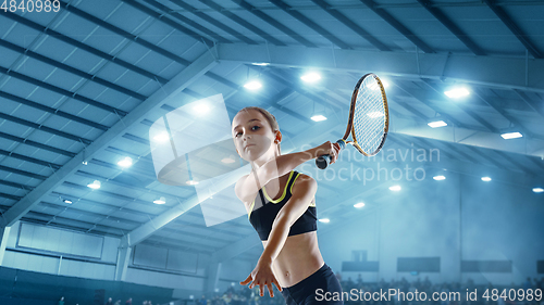 Image of Little caucasian girl playing tennis on sport court background