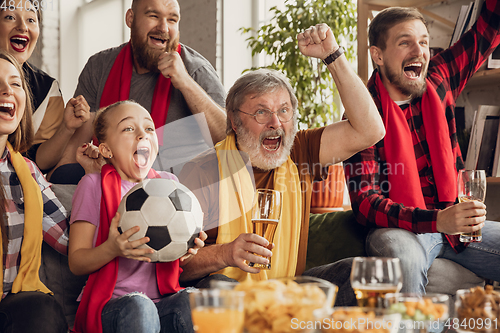 Image of Excited, happy big family team watch football, soccer match together on the couch at home