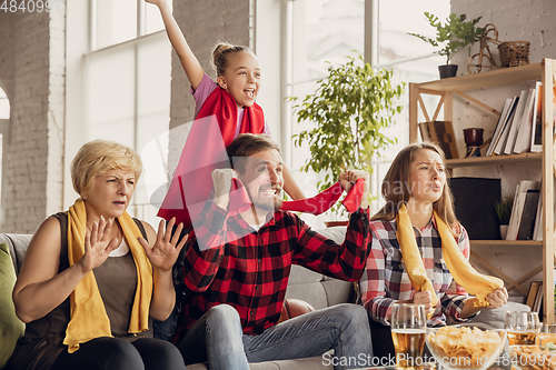 Image of Excited, happy big family team watch football, soccer match together on the couch at home
