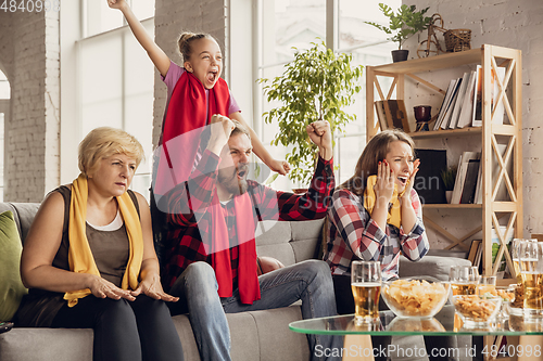 Image of Excited, happy big family team watch football, soccer match together on the couch at home