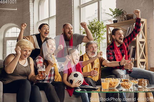 Image of Excited, happy big family team watch football, soccer match together on the couch at home