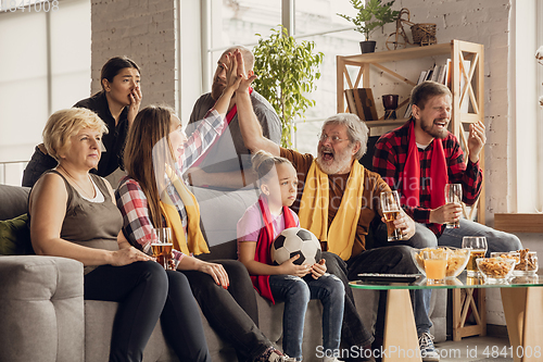 Image of Excited, happy big family team watch football, soccer match together on the couch at home