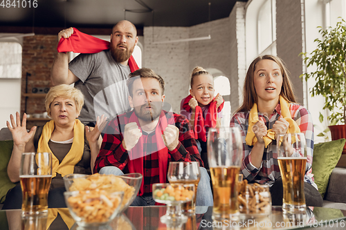 Image of Excited, happy big family team watch football, soccer match together on the couch at home