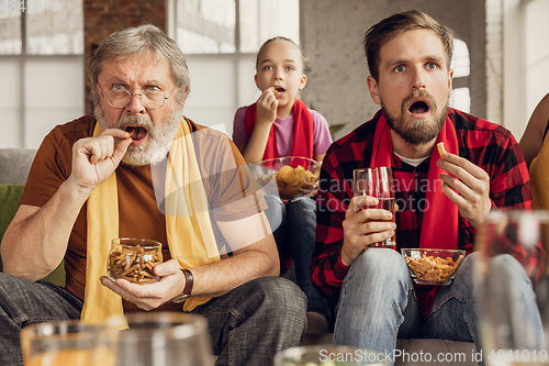 Image of Excited, happy big family team watch football, soccer match together on the couch at home