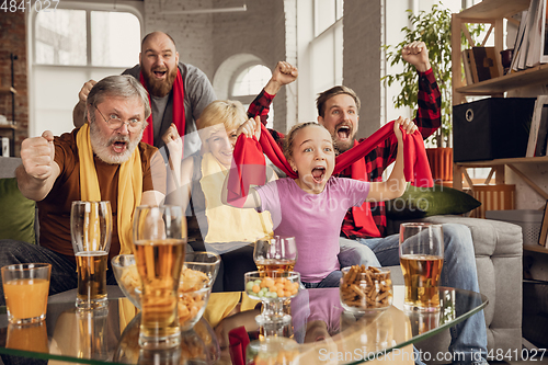 Image of Excited, happy big family team watch football, soccer match together on the couch at home