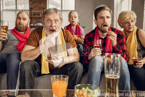 Image of Excited, happy big family team watch football, soccer match together on the couch at home