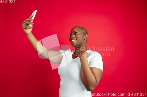 Image of African-american young woman\'s portrait on red background