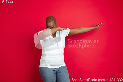 Image of African-american young woman\'s portrait on red background