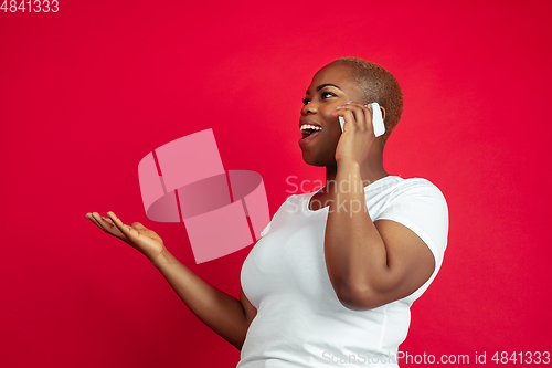 Image of African-american young woman\'s portrait on red background
