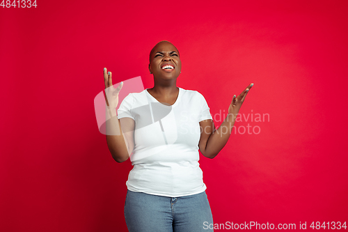 Image of African-american young woman\'s portrait on red background