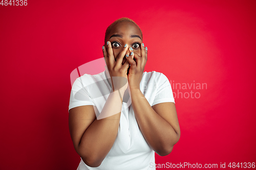 Image of African-american young woman\'s portrait on red background