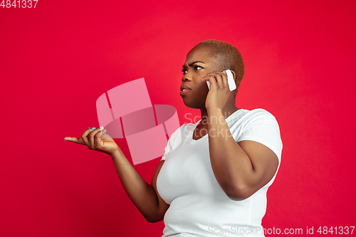 Image of African-american young woman\'s portrait on red background