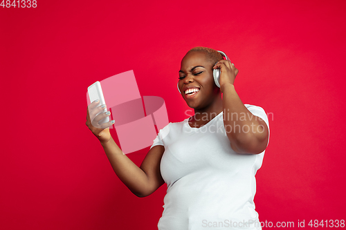 Image of African-american young woman\'s portrait on red background